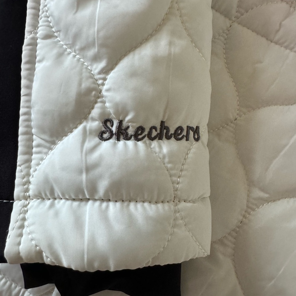 Skechers jacket white and black quilted with hood and thumb holes super soft.